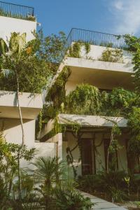 
a house with a balcony and a tree at Jashita Tulum Luxury Villas in Tulum
