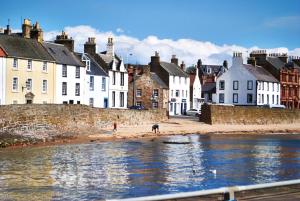 a group of houses on a beach next to the water at Little Acorn - 2-Bed Anstruther Apartment in Anstruther