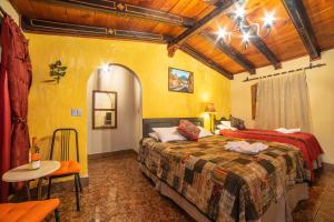 a bedroom with a bed and a table in a room at Hotel Gran Plaza Euromaya in Antigua Guatemala