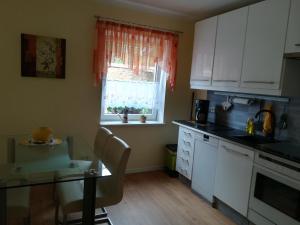 a kitchen with white cabinets and a table and a window at Ferienwohnung Bittner in Klitten