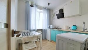 uma cozinha com armários azuis e uma mesa com cadeiras em Квартира біля центральної площі Перспективна 22 em Oleksandriya