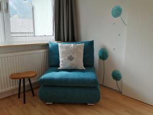 a blue chair with a pillow in a room at Sand 4 in Stanzach