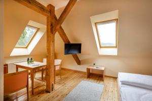 a room with a table and a tv in a attic at JUFA Hotel Judenburg in Judenburg