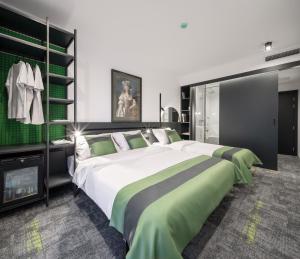 a bedroom with a large bed with green and white sheets at Joy 5 Hotel & SPA in Belgrade
