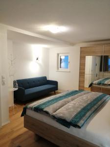 a bedroom with a large bed and a blue couch at Sand 4 in Stanzach