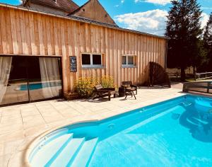 a swimming pool in front of a building with a house at Pool house-L'hirondelle de Sermizelles- grand jardin, calme et nature aux portes du Morvan in Sermizelles