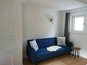 a blue couch in a living room with a window at Sand 4 in Stanzach +43 photos