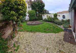 un jardín con un pequeño patio con un árbol en DAIREAUX HOUSE en Mar del Plata