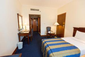 een hotelkamer met een bed en een bureau bij York International Hotel in Dubai