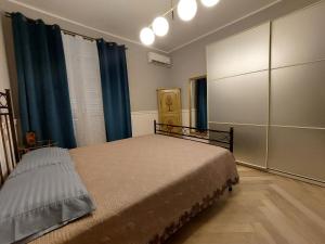 a bedroom with a bed and blue curtains at Casa Madama Rossini in Turin