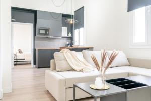 sala de estar con sofá blanco y mesa en Suites Alfonso X, en Jerez de la Frontera