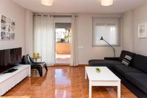a living room with a black couch and a table at Chalet Coral Denia in Denia