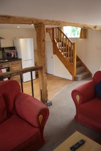 a living room with two couches and a staircase at Little Oaks in Stowmarket
