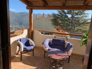two chairs and a table on a balcony with a view at Casa vacanze Mideri in Urzulei