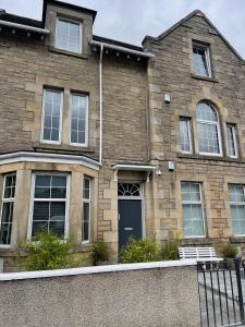 a brick house with a blue door and windows at Premier Apartment C in Broxburn