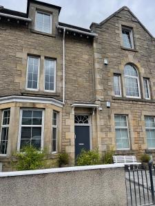 a brick house with a blue door and windows at Premier 2 bed Flat C in Broxburn