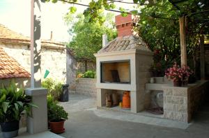 a outdoor kitchen with a brick oven in a yard at Villa Violić in Zaton