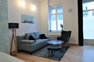 - un salon avec un canapé, une chaise et une table dans l'établissement Apartment Lodge 61, à Berlin