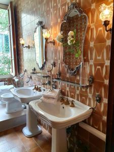 a bathroom with a sink and a toilet and a mirror at Villa Lia - Apartment in Villa with private garden and Pool in Florence