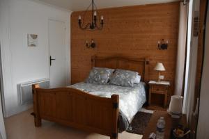 1 dormitorio con 1 cama y pared de madera en Ker-Loën, en Val Couesnon