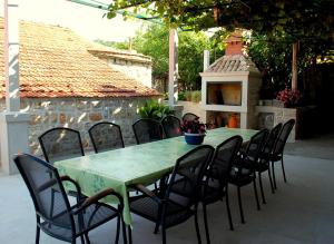 a green table and chairs on a patio at Villa Violić in Zaton