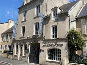un bâtiment au coin d'une rue dans l'établissement Appart’hôtel saint patrice, à Bayeux