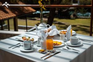een tafel met borden met eten en drinken bij Hotel Villarma in Alis