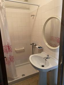 uma casa de banho com um lavatório, um espelho e uma banheira em Hostatgeria i Restaurant Coll de Condreu em Les Planes d'Hostoles