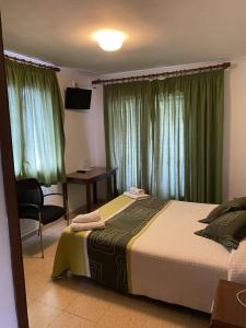 um quarto com uma cama, uma secretária e uma janela em Hostatgeria i Restaurant Coll de Condreu em Les Planes d'Hostoles