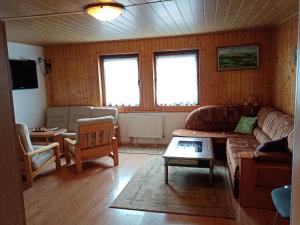 a living room with a couch and a table at Šumavská rekreační chalupa in Pohorsko