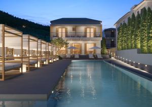 a swimming pool in front of a building at Olia Green Residence in Skopelos Town