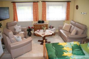 ein Wohnzimmer mit einer Couch und Stühlen und einem Tisch in der Unterkunft Fewo Rabe in Lauterbach