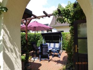 eine Terrasse mit Stühlen, einem Tisch und einem Sonnenschirm in der Unterkunft Fewo Rabe in Lauterbach