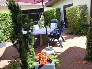 eine Terrasse mit Tisch und Stühlen und Blumen in der Unterkunft Fewo Rabe in Lauterbach