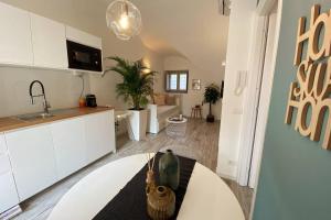 sala de estar con mesa y cocina en Casa Meraki - Apartment en Bergamo