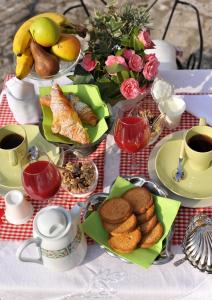 einen Tisch mit Teller mit Speisen und Tassen Kaffee in der Unterkunft B&B Ronco degli Ulivi in Iseo