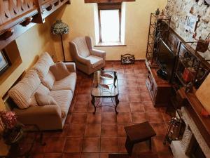 a living room with two couches and a television at Casa Rural El Puente in Polvoredo