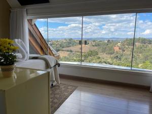 una habitación con una ventana grande con vistas en Bela Vista Chalé, en Campos do Jordão