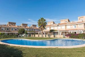 a swimming pool in front of a large building at Chalet Harley Denia in Denia