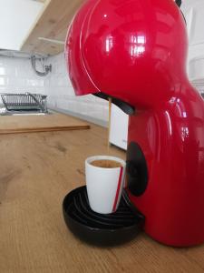 una macchinetta del caffè che versa il caffè in una tazza sul tavolo di Tiny House Faro a Faro