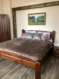 a bedroom with a large wooden bed with pillows at Загородный отель Слобода, Ясная Поляна, Тула in Samokhvalovka