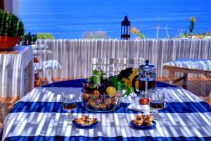 a blue and white table with a bowl of fruit and drinks at La Terrazza sul Mare di Teodora in Pantelleria