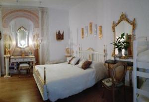 a bedroom with a bed and a desk and a mirror at Império Romano Guest House in Beja