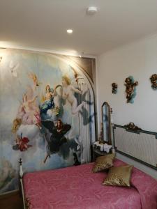 a bedroom with a large painting on the wall at Império Romano Guest House in Beja