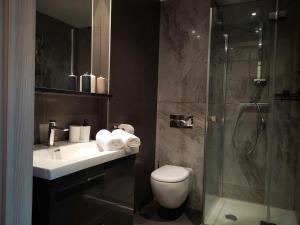 a bathroom with a toilet and a sink and a shower at SleepWell in Zielona Góra