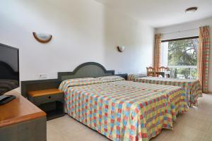 a bedroom with two beds and a flat screen tv at Apartamentos San Miguel Park & Esmeralda Mar in Puerto de San Miguel