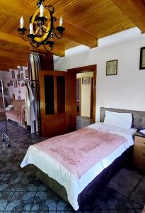 a bedroom with a large bed and a chandelier at Guest House Marketti in Vynohradiv