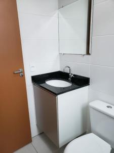 uma casa de banho com um lavatório e um WC em Jardim das Palmeiras II Home Resort JP2 Ubatuba - Apartamento com 2 Dorms, 1 Suíte, Churrasqueira Gourmet, Piscina Adulto e Infantil, Jacuzzi Aquecida, Sauna, Academia, Salão de Jogos e Playground em Ubatuba