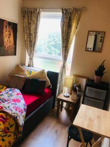 a living room with a couch and a window at Archery Close in Harrow Weald