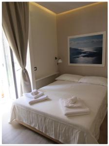 ナポリにあるViola's Homeのベッドルーム1室(白いベッド1台、タオル付)